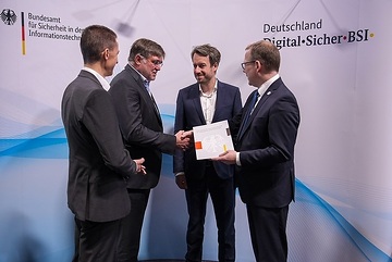 Anlässlich der metering days 2023 überreichten die BSI-Mitarbeiter Dennis Laupichler (links) und Matthias Intemann (rechts) dem EFR-Geschäftsführer Martin Eibl (2. v. l.) und Paul Martin Halm (Bereichsleiter Produkt-/Systementwicklung, 3. v. l.) am 17. Oktober 2023 das Zertifikat für das SMGw der EFR "Smart Grid Hub – Secure" (SGH-S).

 efrsmgwzert
